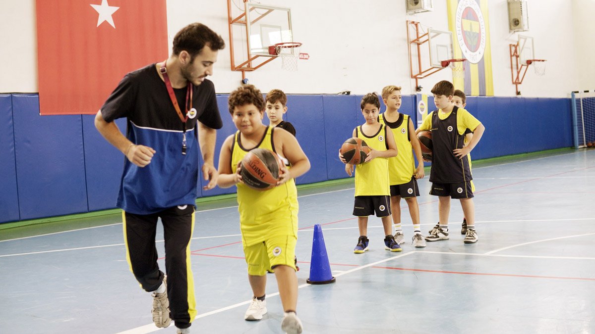 Antrenör eşliğinde basketbol öğrenen çocuklar